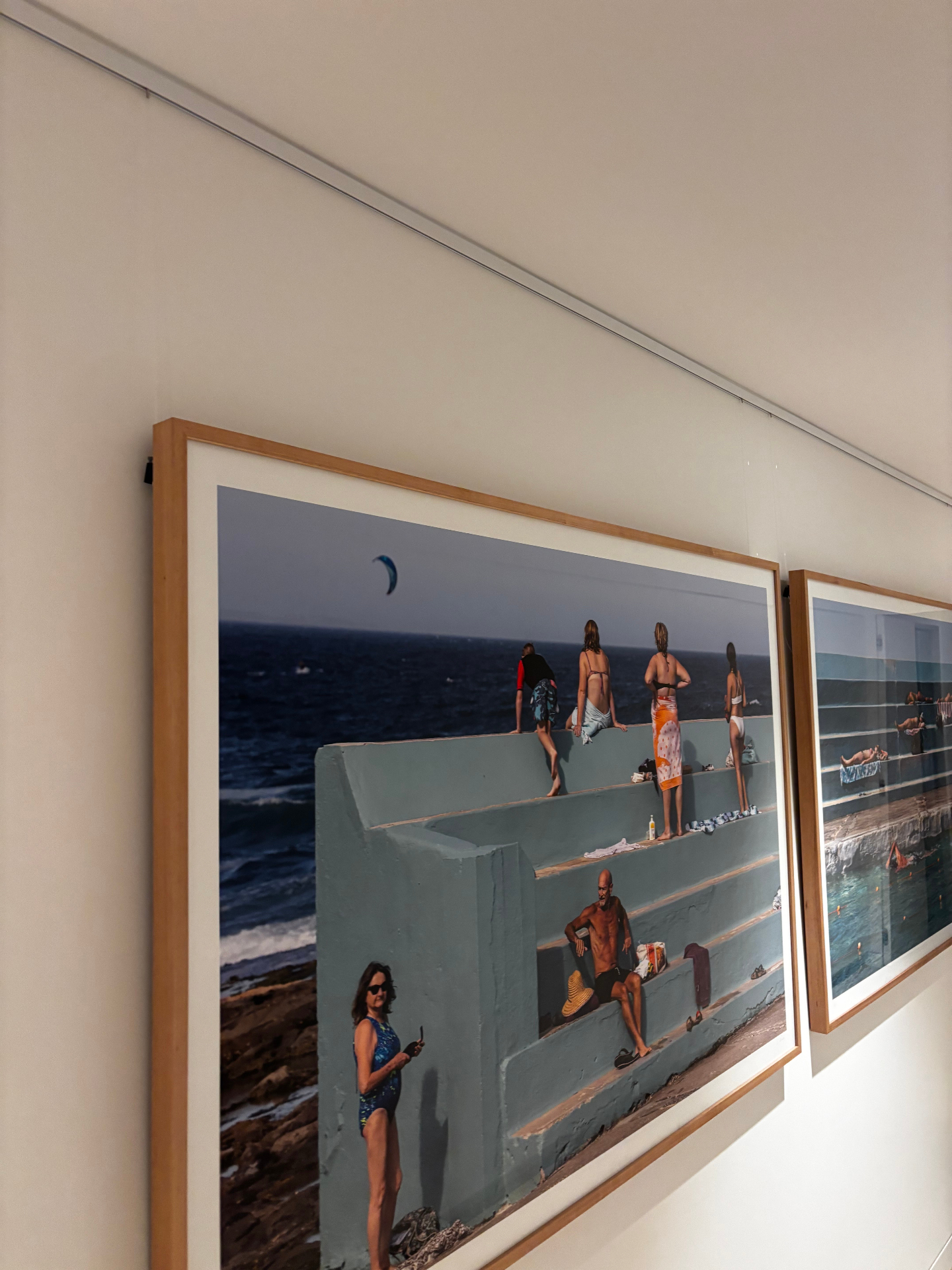 Large beach photographs on white rail with nylon wires