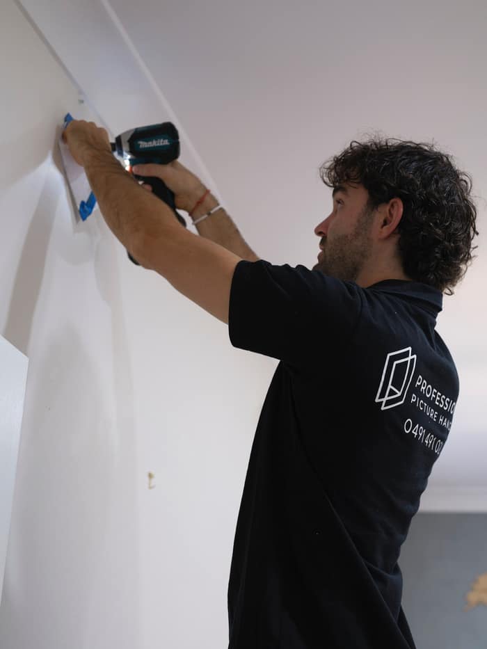 PPH installer fixing a picture rail to the wall